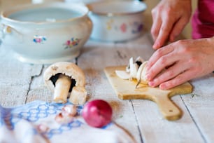 Unrecognizable man in the kitchen cutting mushrooms