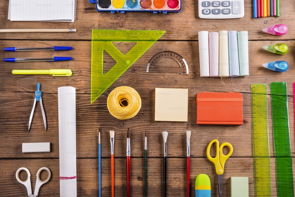 Desk with stationary and with Back to school sign. Studio shot on wooden background.