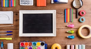 Desk with stationary and a picture frame. Studio shot on wooden background.