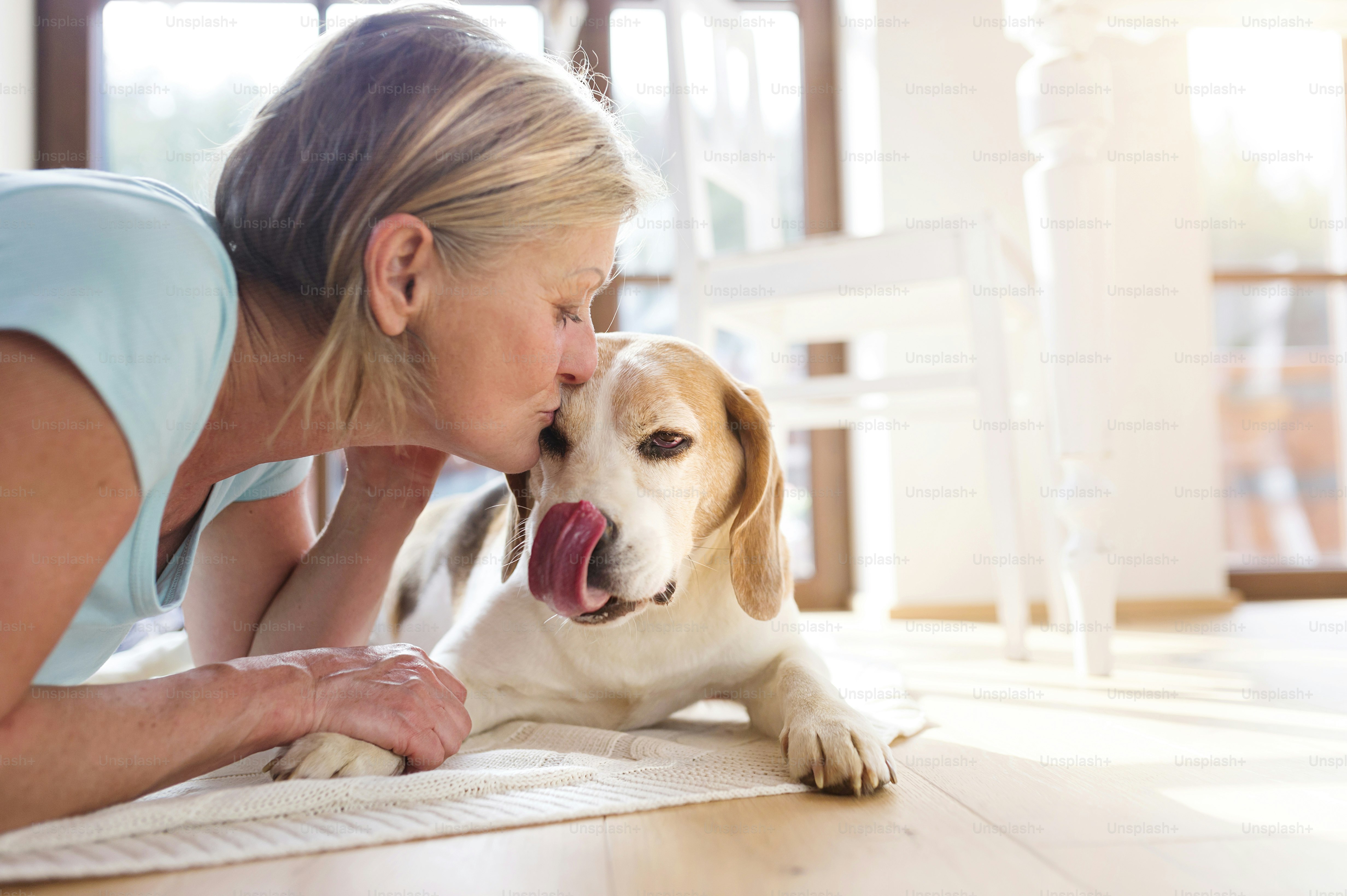 Senior woman with dog inside of her house.