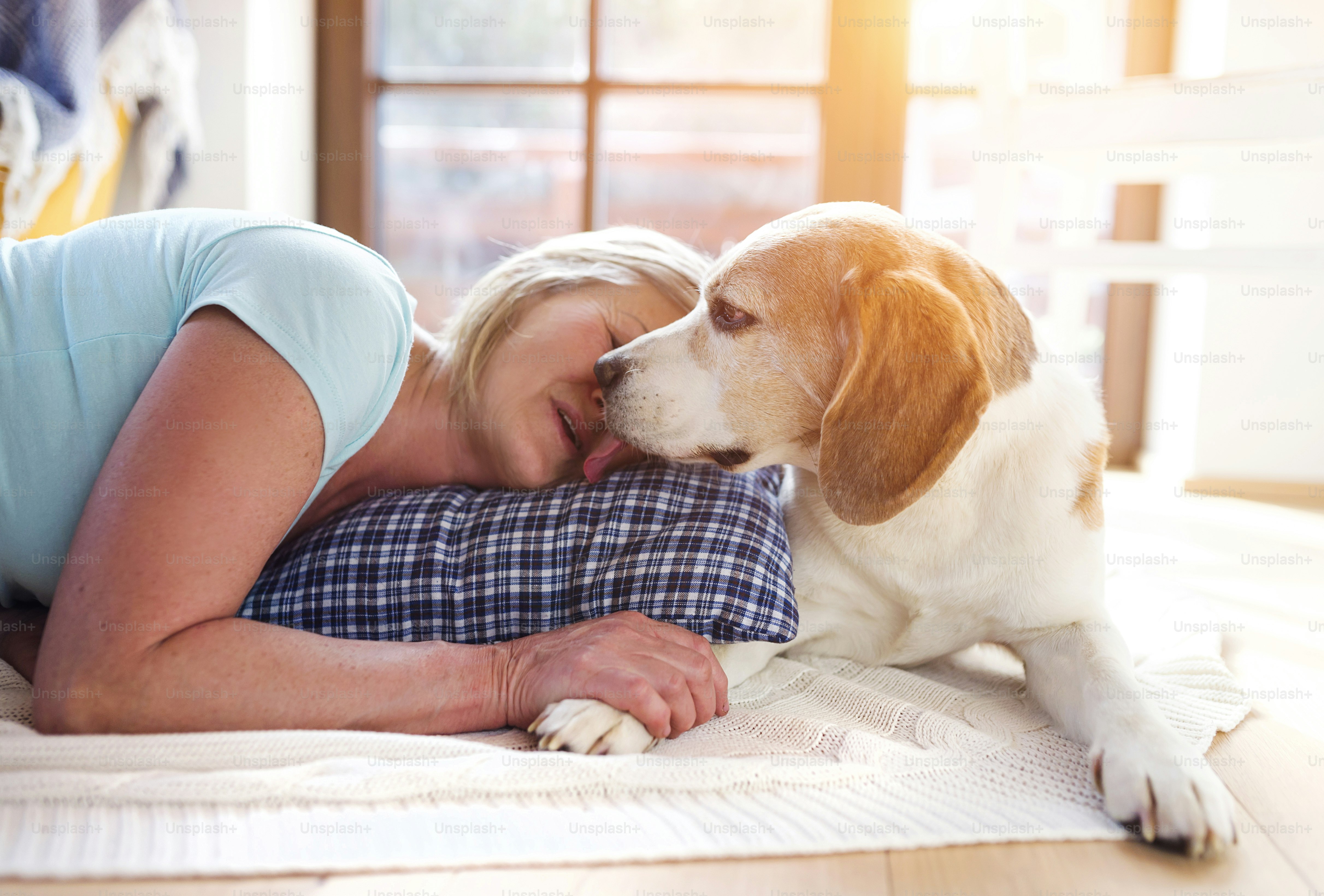 Senior woman with dog inside of her house.