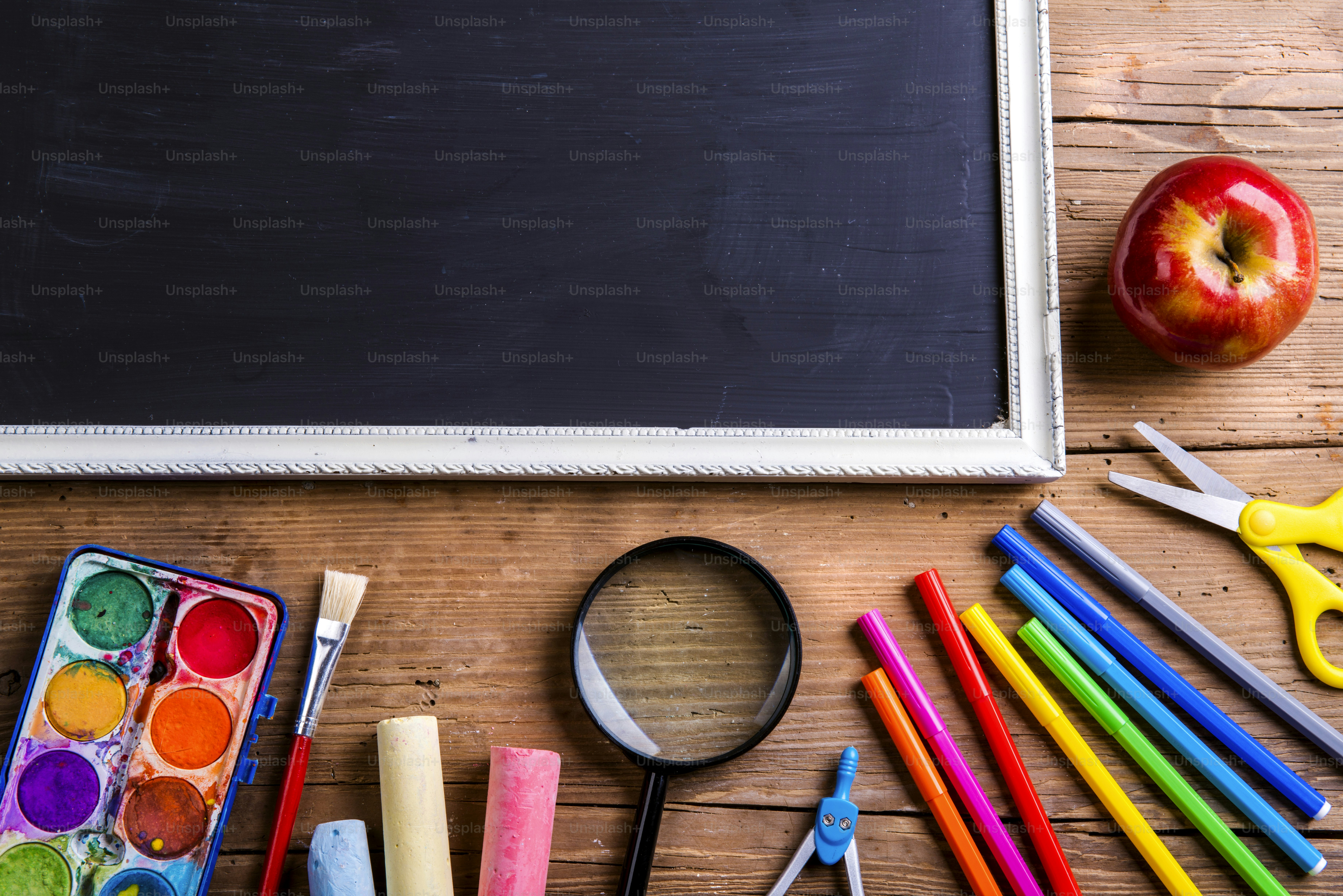 Desk with school supplies. Studio shot on wooden background.