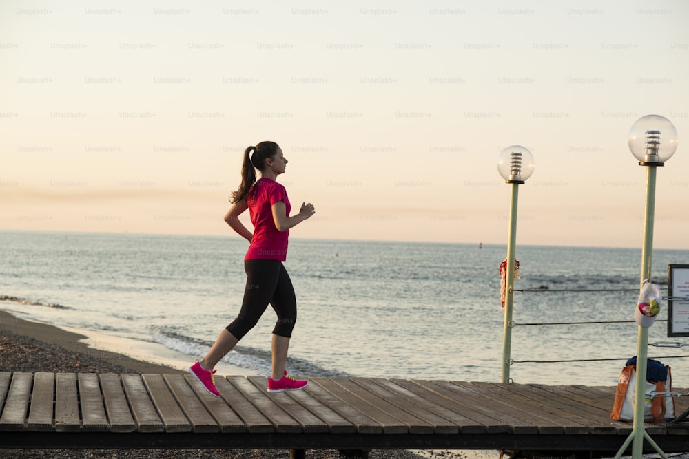 Femme qui court. Coureuse faisant du jogging lors d’une séance d’entraînement en plein air sur la plage.
