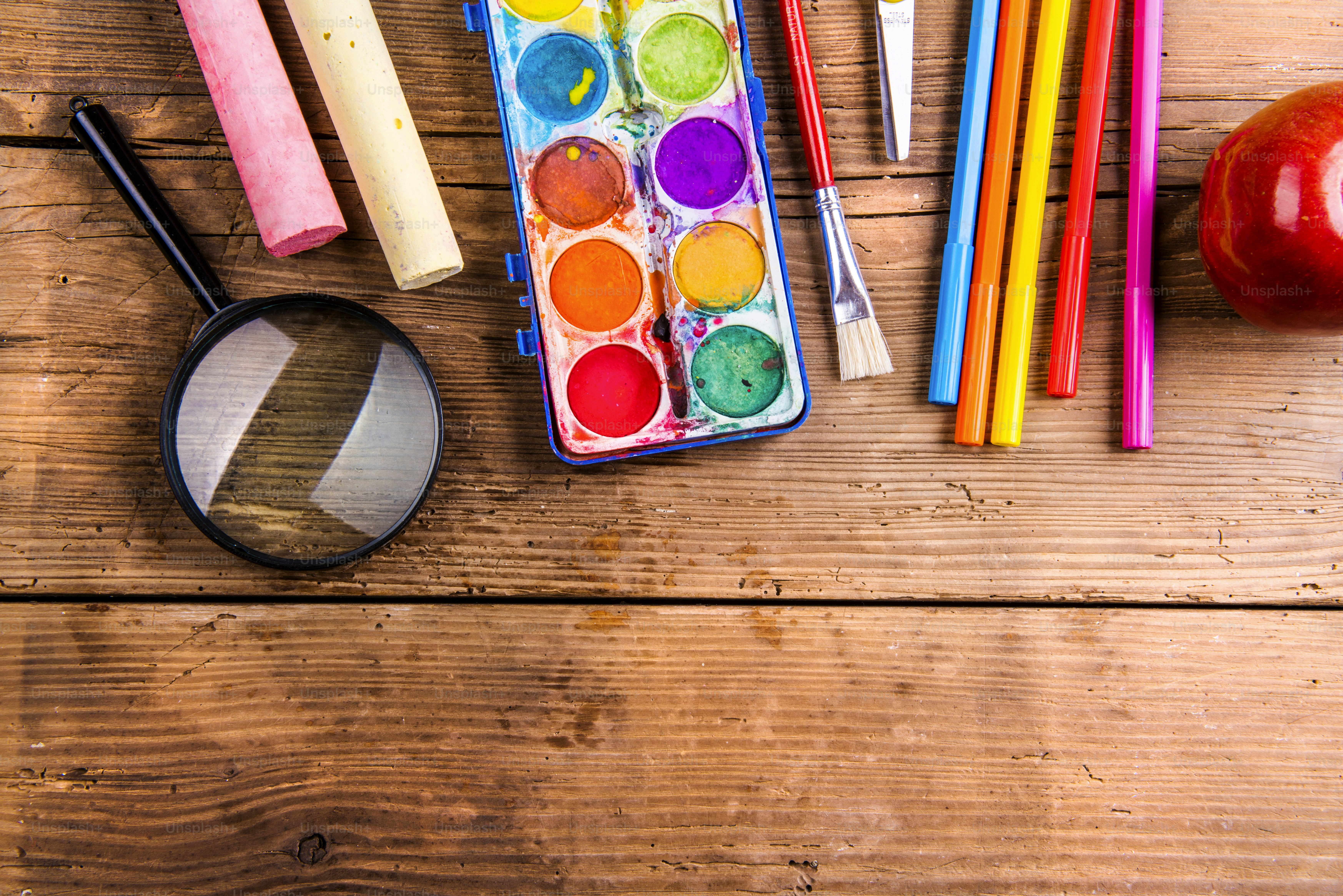 Desk with school supplies. Studio shot on wooden background.