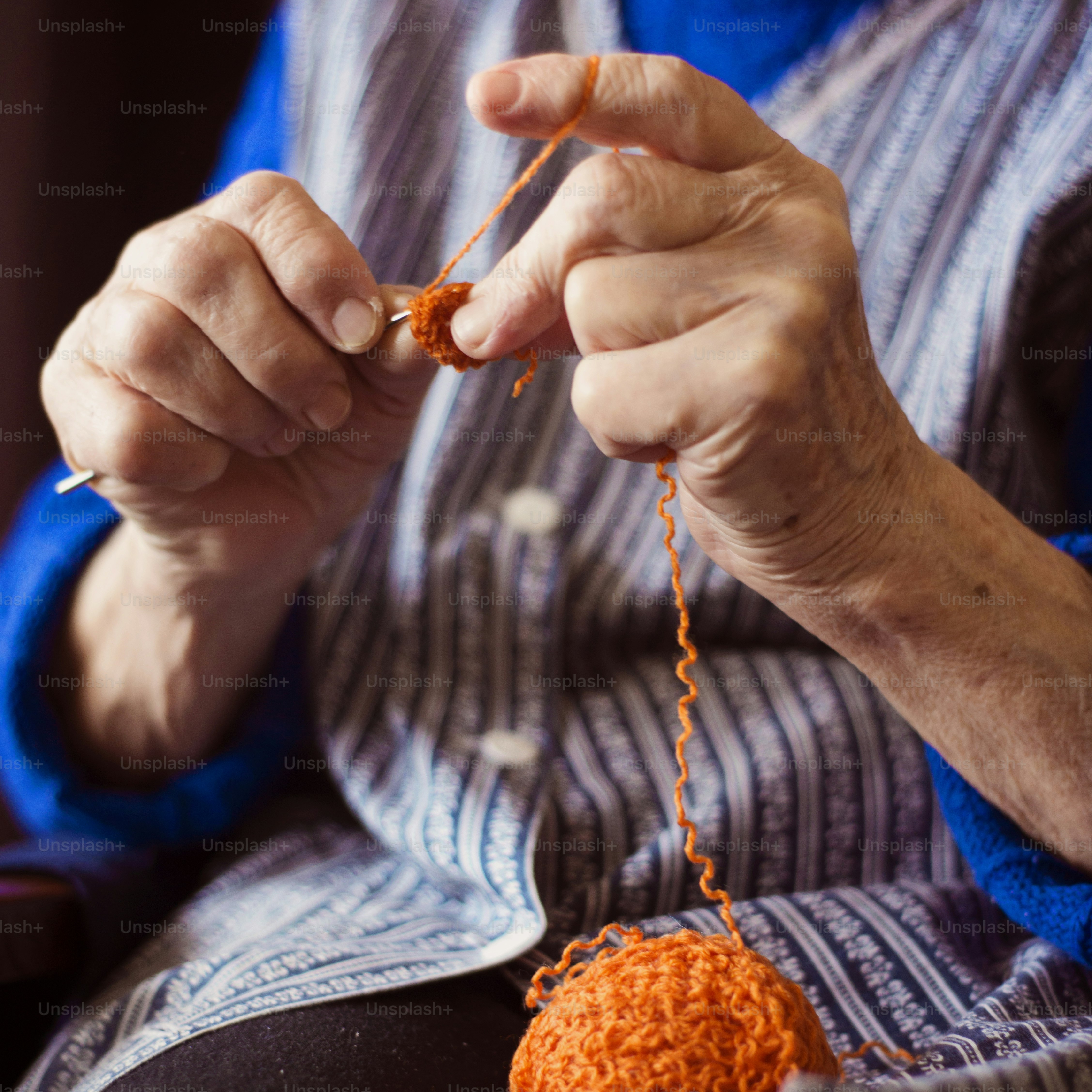 Hands of senior woman knitting with wool and knitting needles photo