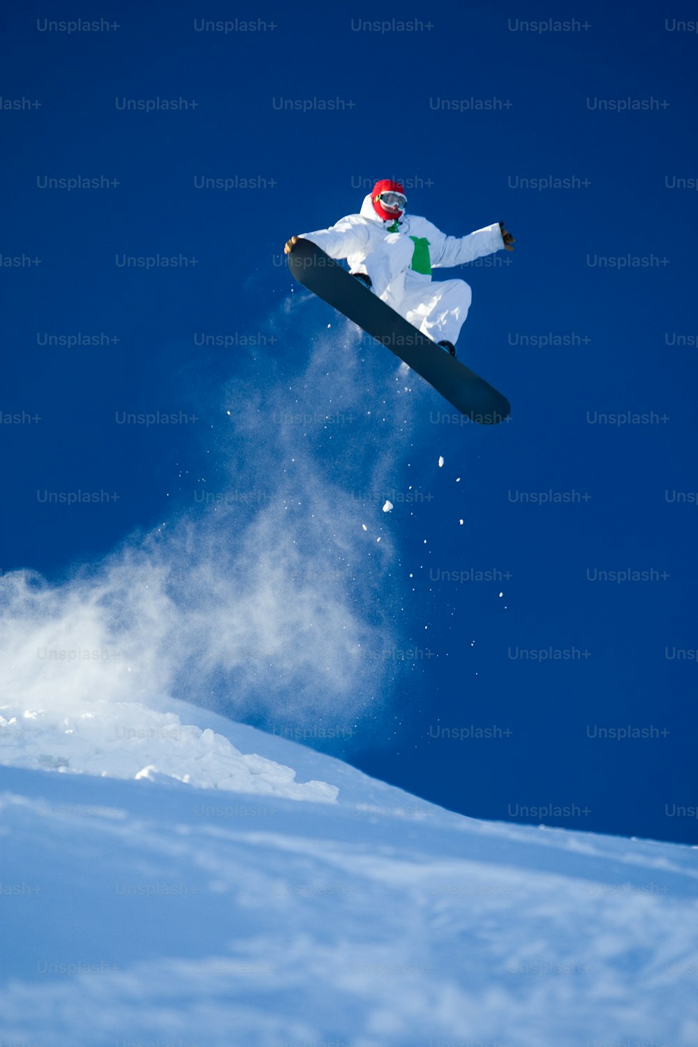 青空にスノーボードで飛び乗る勇敢なスポーツマンの写真