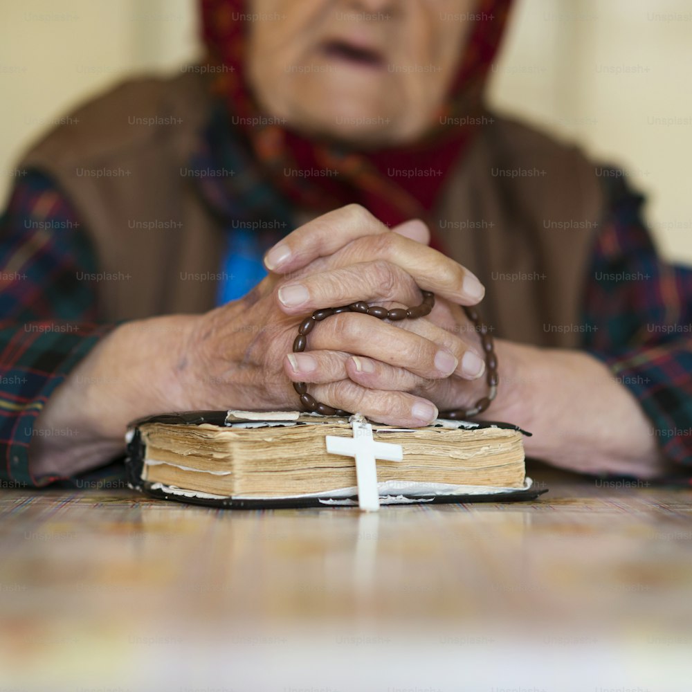 Detalle de una mujer muy anciana con pañuelo en la cabeza rezando