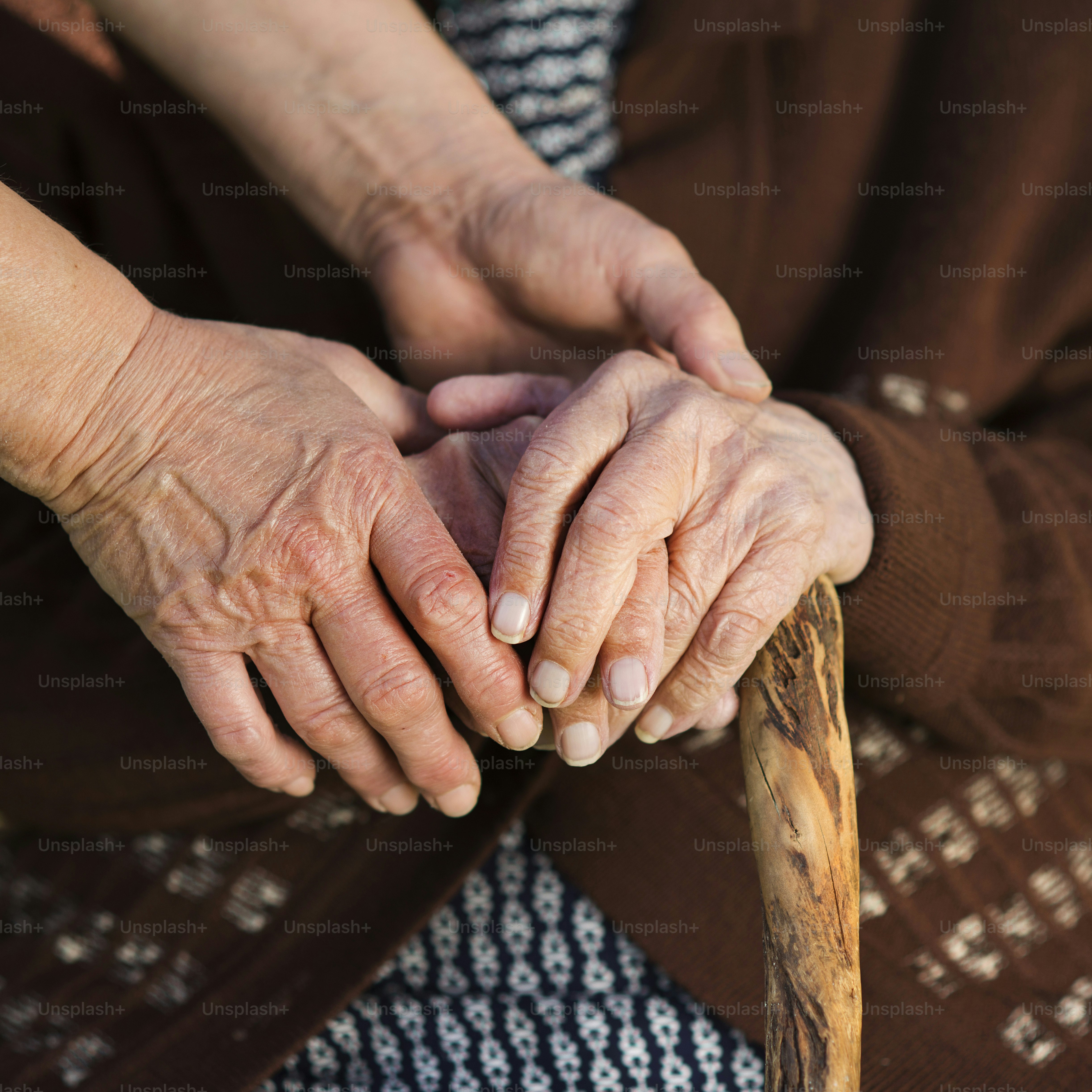 Family members holding an older adult's hands in support
