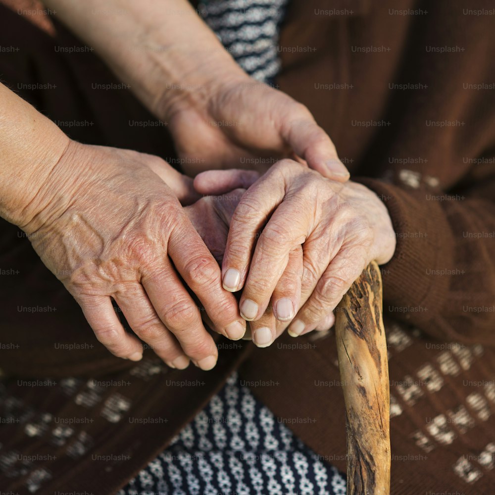 Closeup of caring woman holding female senior's hands