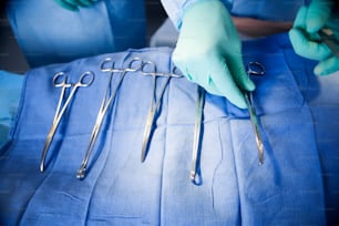 a person with surgical gloves and surgical equipment
