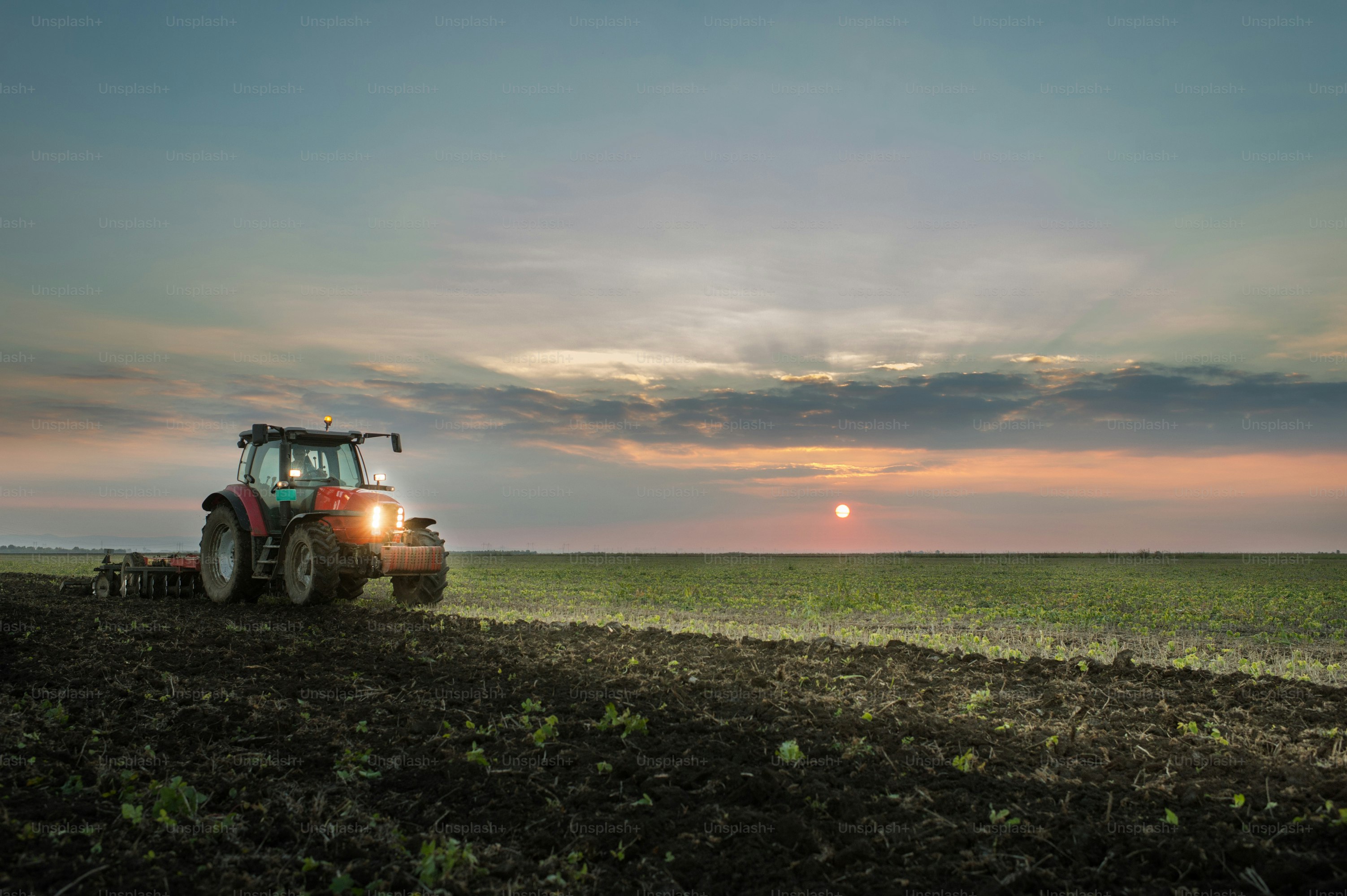 Tractor plowing a field at dusk