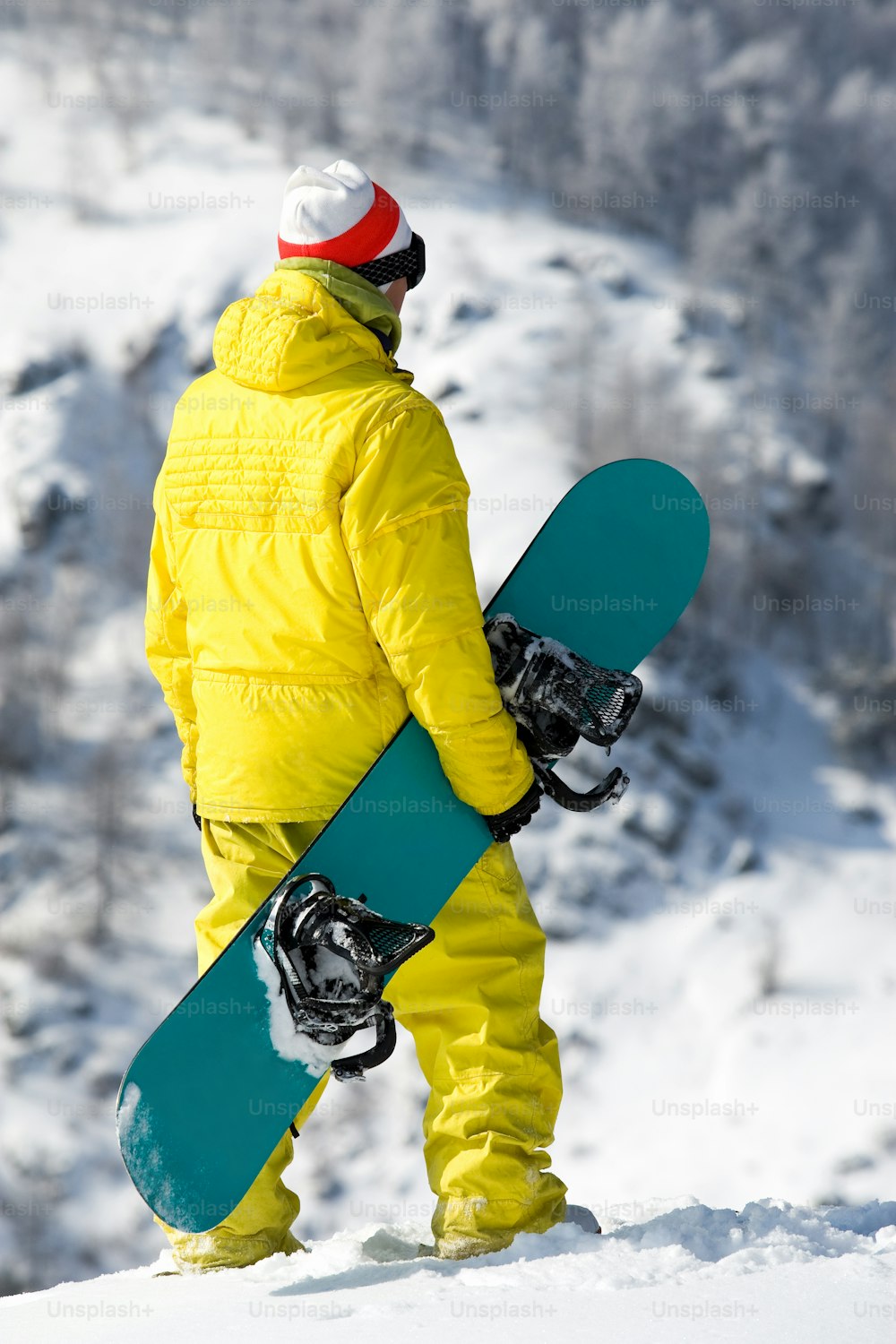 Rear view of snowboarder standing in snowdrift in winter    Note to inspector: the image is pre-Sept 1 2009