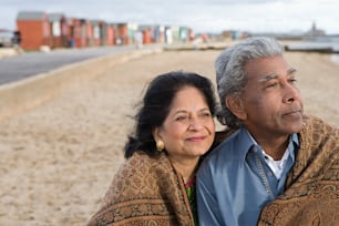 Ein Mann und eine Frau sitzen am Strand
