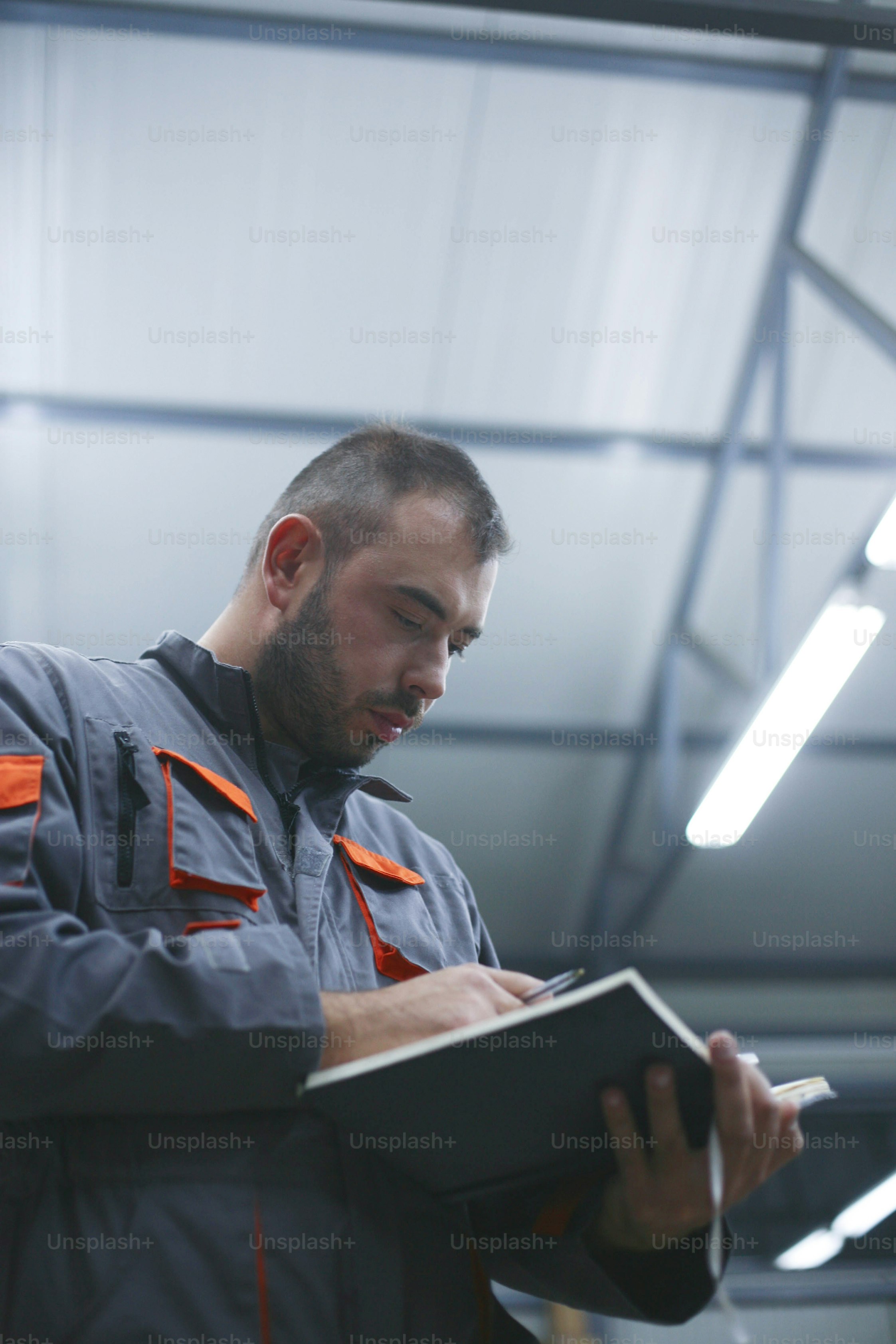 Man reading his notebook in workshop.