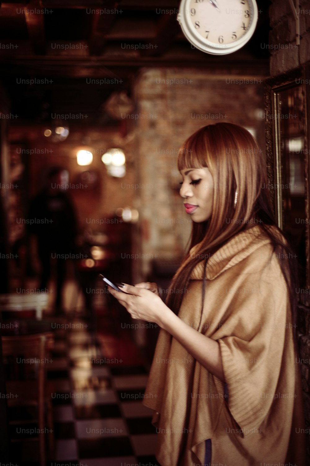 Mujer afroamericana usando teléfono móvil.