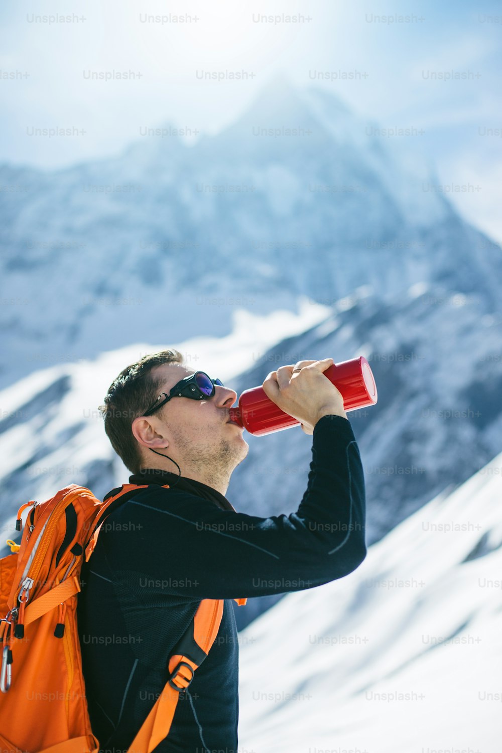 Excursionista bebiendo agua en montañas. Al fondo se encuentra el Machapuchare (6993m) también conocido como Cola de Pez, hasta el día de hoy esta cumbre no ha sido escalada.