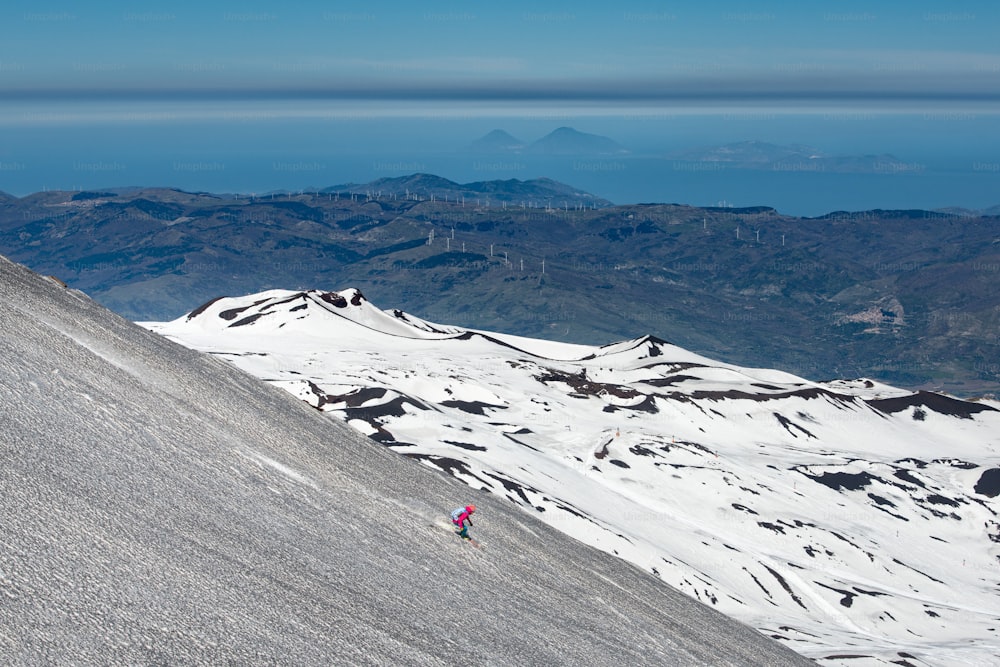 Skier sur le volcan Etna avec en toile de fond Lipari Stromboli Îles Éoliennes Italie