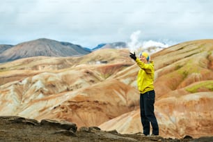 woman hiker photographer taking selfie on the rhyolite mountains background in Iceland