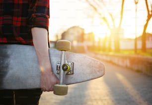 Rückansicht eines Skateboard-Mädchens, das das Skateboard hält