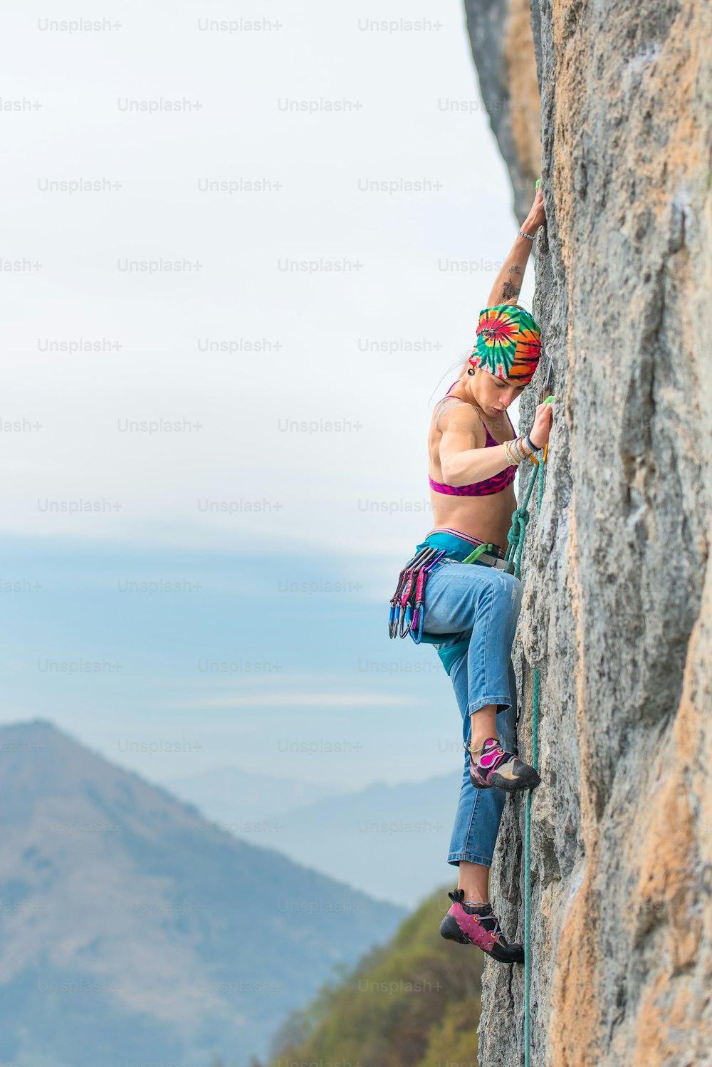 Young woman stairs a wall during a rock course 
