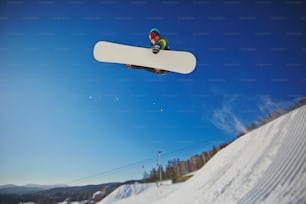 겨울 리조트에서 점프를 하는 스노보드의 프리스타일러