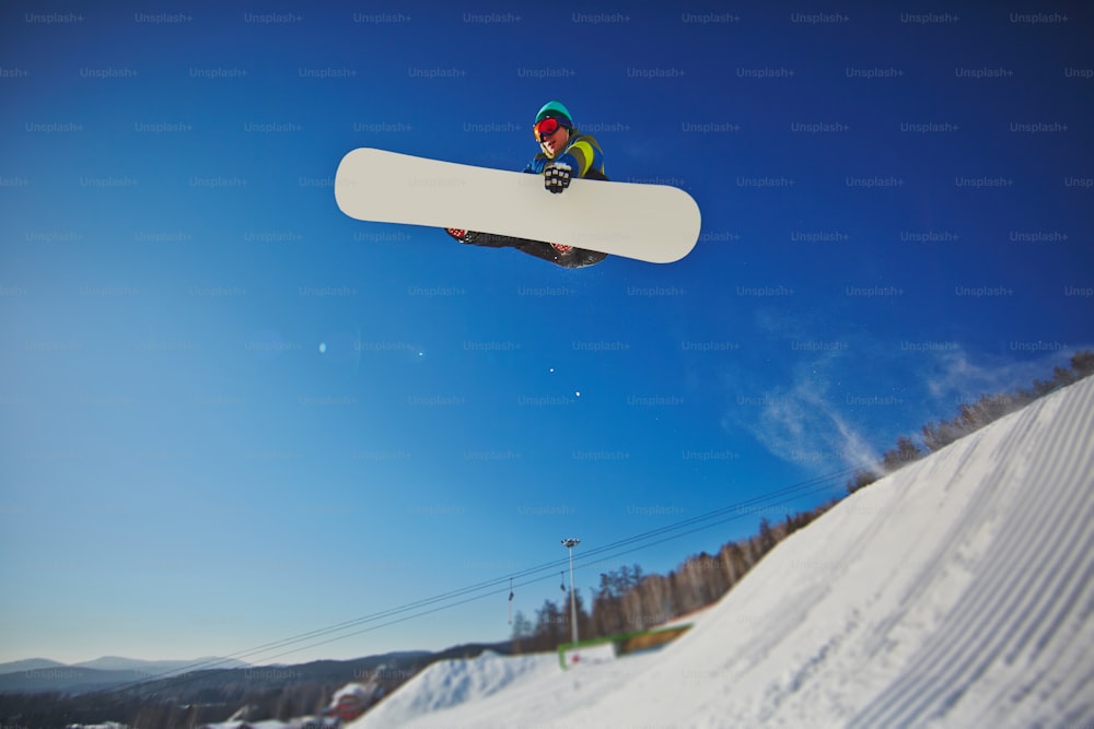 Freestyler sur snowboard volant en saut à la station d’hiver