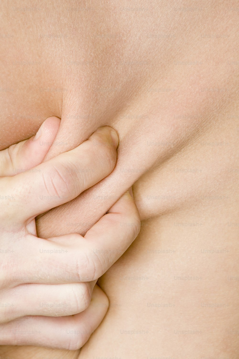 a close up of a woman's breast with her hands on her chest