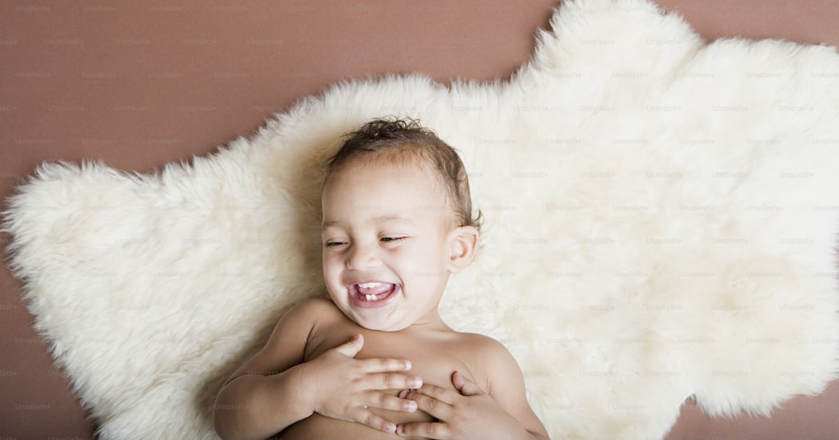 Un petit garçon allongé sur un tapis photo – Image de Bébé qui rit sur ...
