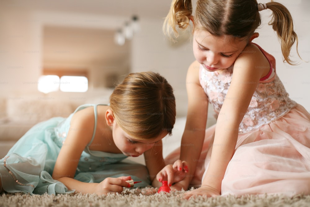 Due bambine si sono dipinte le unghie a casa.