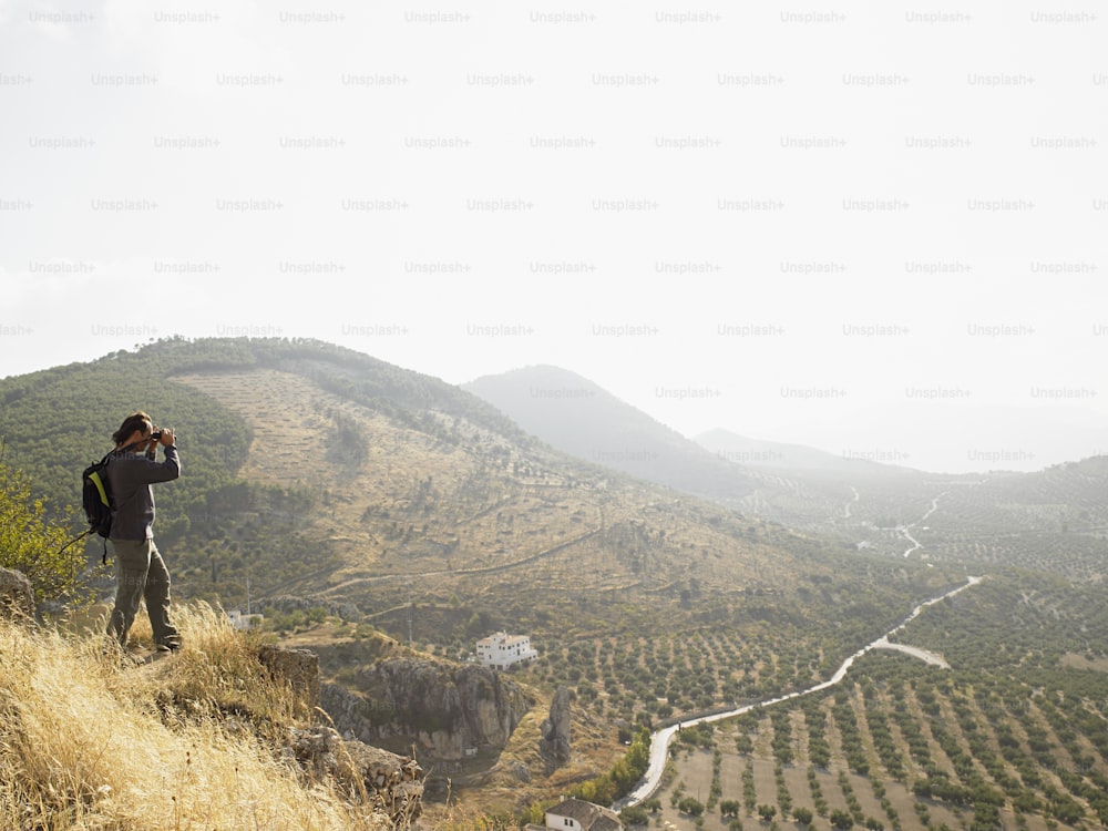 a man standing on top of a lush green hillside