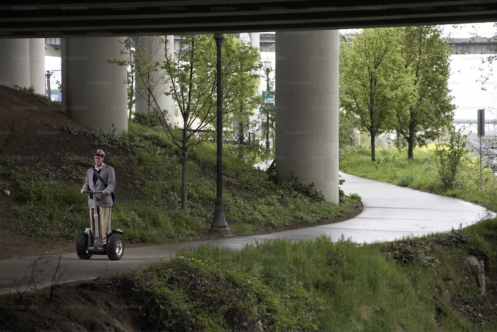 Un uomo che guida uno scooter elettrico lungo una strada