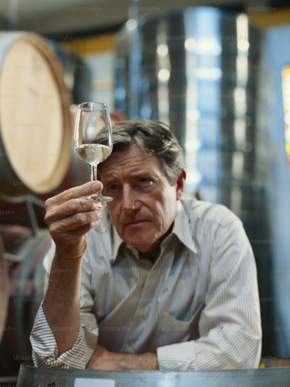 Un hombre sosteniendo una copa de vino blanco