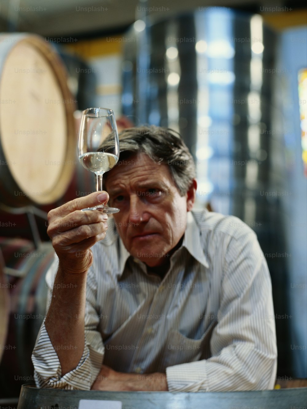 a man holding a glass of white wine