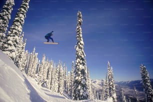um homem voando pelo ar enquanto anda de snowboard