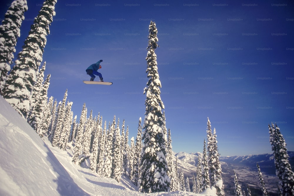 a man flying through the air while riding a snowboard