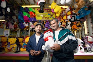 two men standing in front of a display of stuffed animals