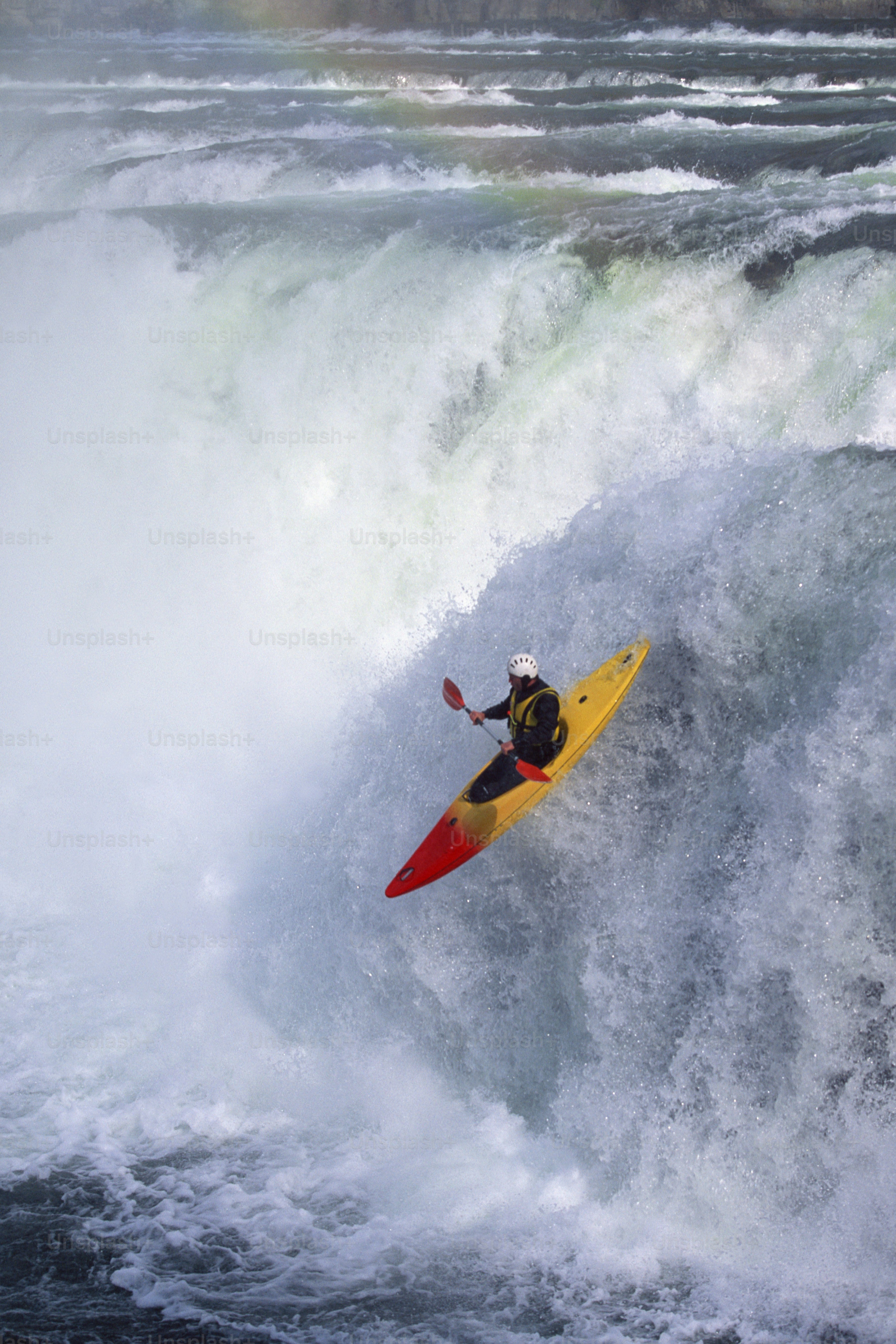 a man riding a wave on top of a yellow surfboard