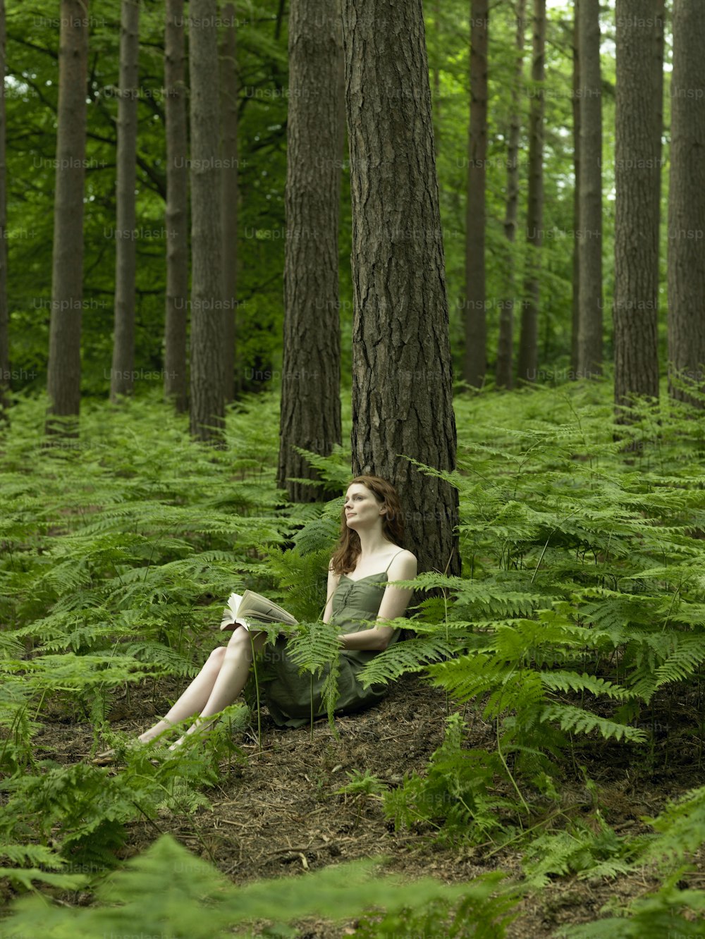 a woman is sitting in the middle of a forest