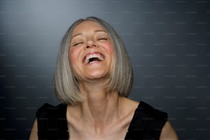 a woman laughing with her eyes closed