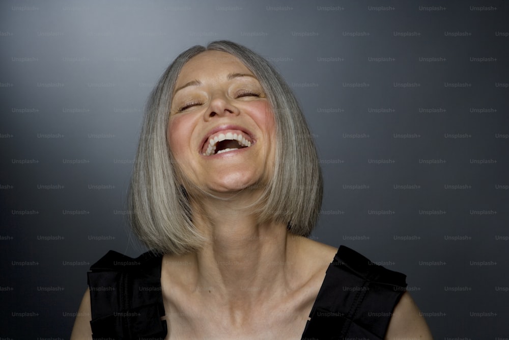 a woman laughing with her eyes closed