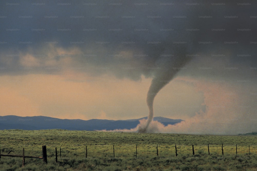 um grande tornado está saindo de um campo