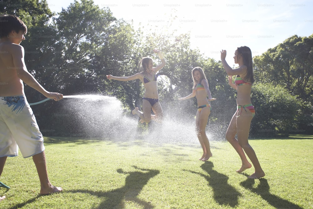 a group of children playing with a sprinkler