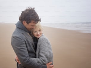 Un hombre abrazando a una mujer en la playa