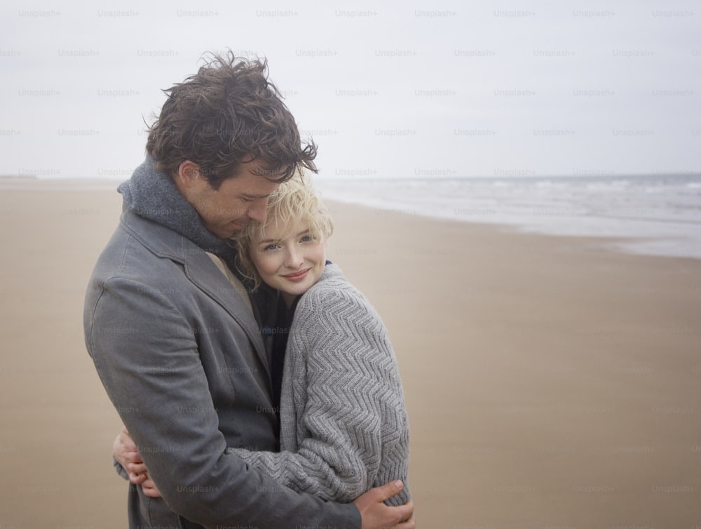 um homem abraçando uma mulher na praia