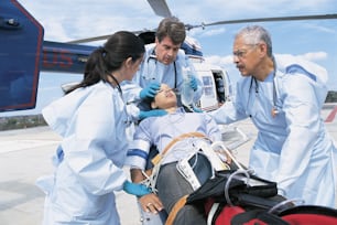 a group of medical personnel standing around a woman on a gurney