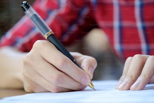 Man is signing on a paper.