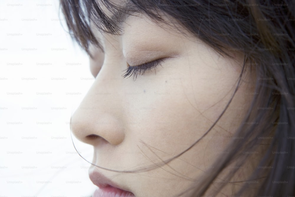 a close up of a woman with her eyes closed