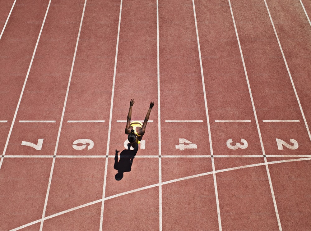 a person standing on a track with their hands in the air
