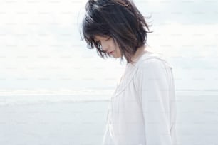 a woman standing on a beach next to the ocean