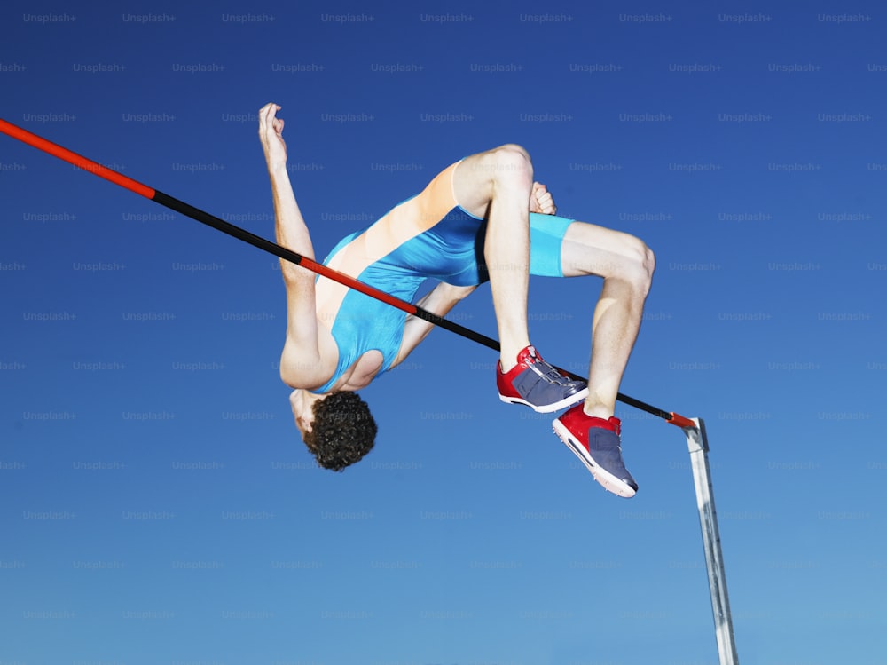 a man is high in the air on a pole